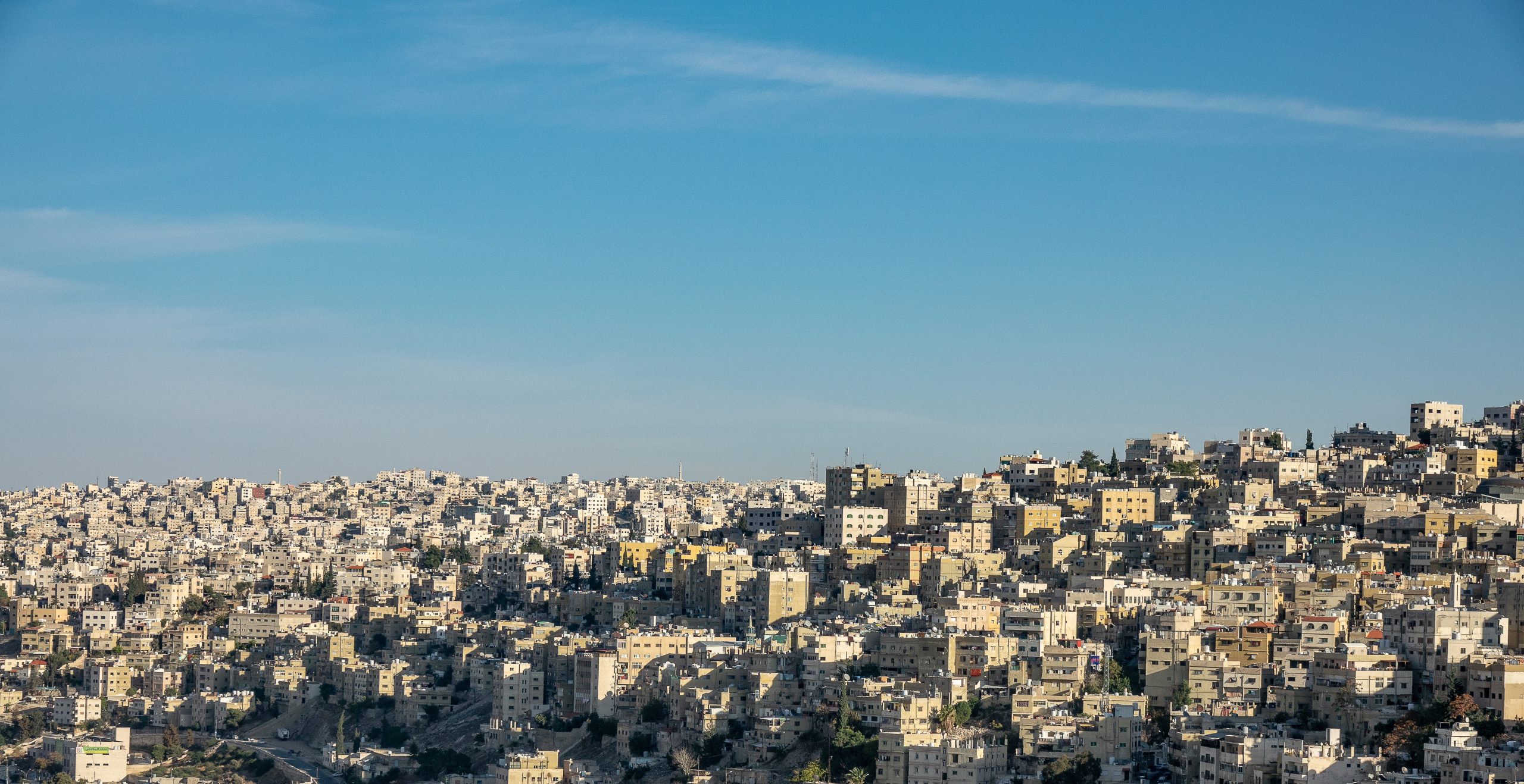 A wide angle shot of several buildings of a city under a clear blue sky